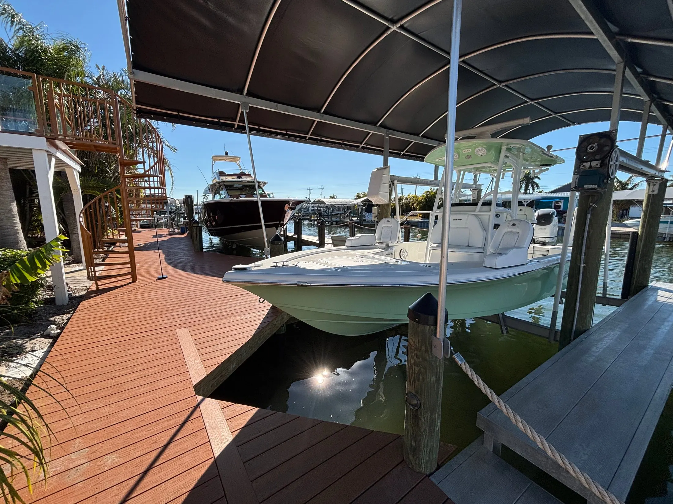 Dock & Dredge: boat on a covered lift beside a waterfront dock