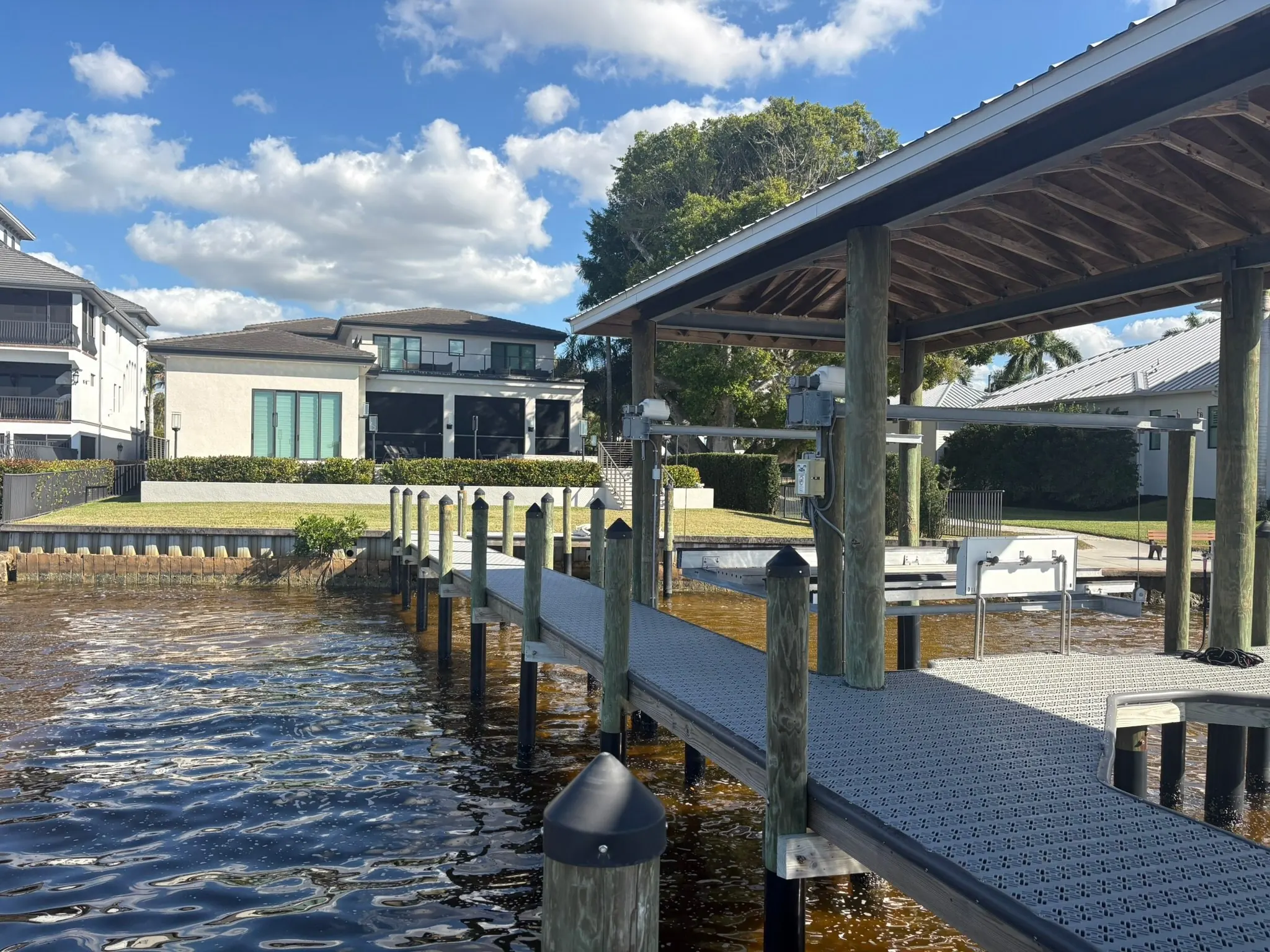 Dock & Dredge: covered boat lift and dock beside a residential waterway