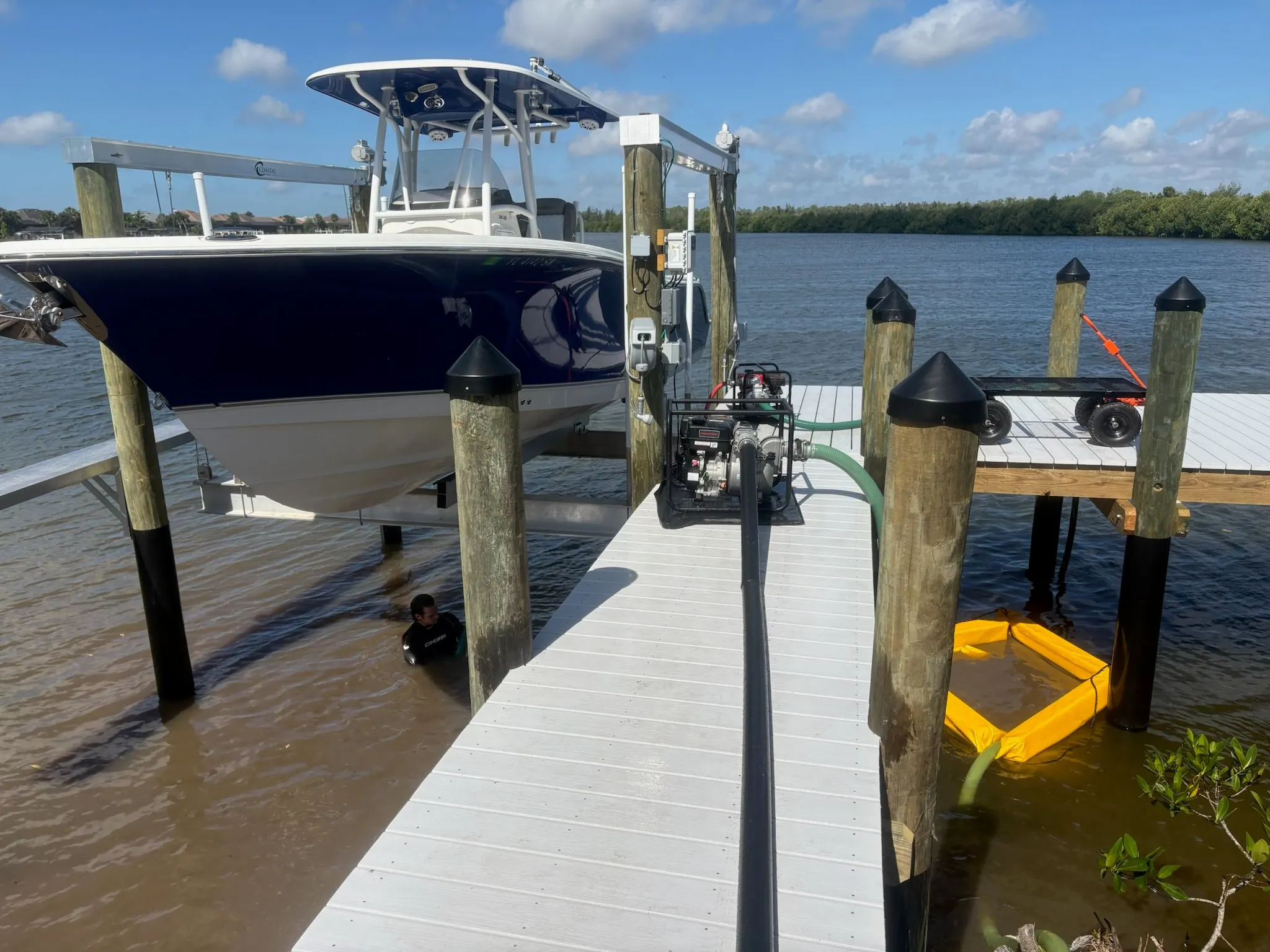 Dock & Dredge: pump and hoses on a dock beside a raised boat