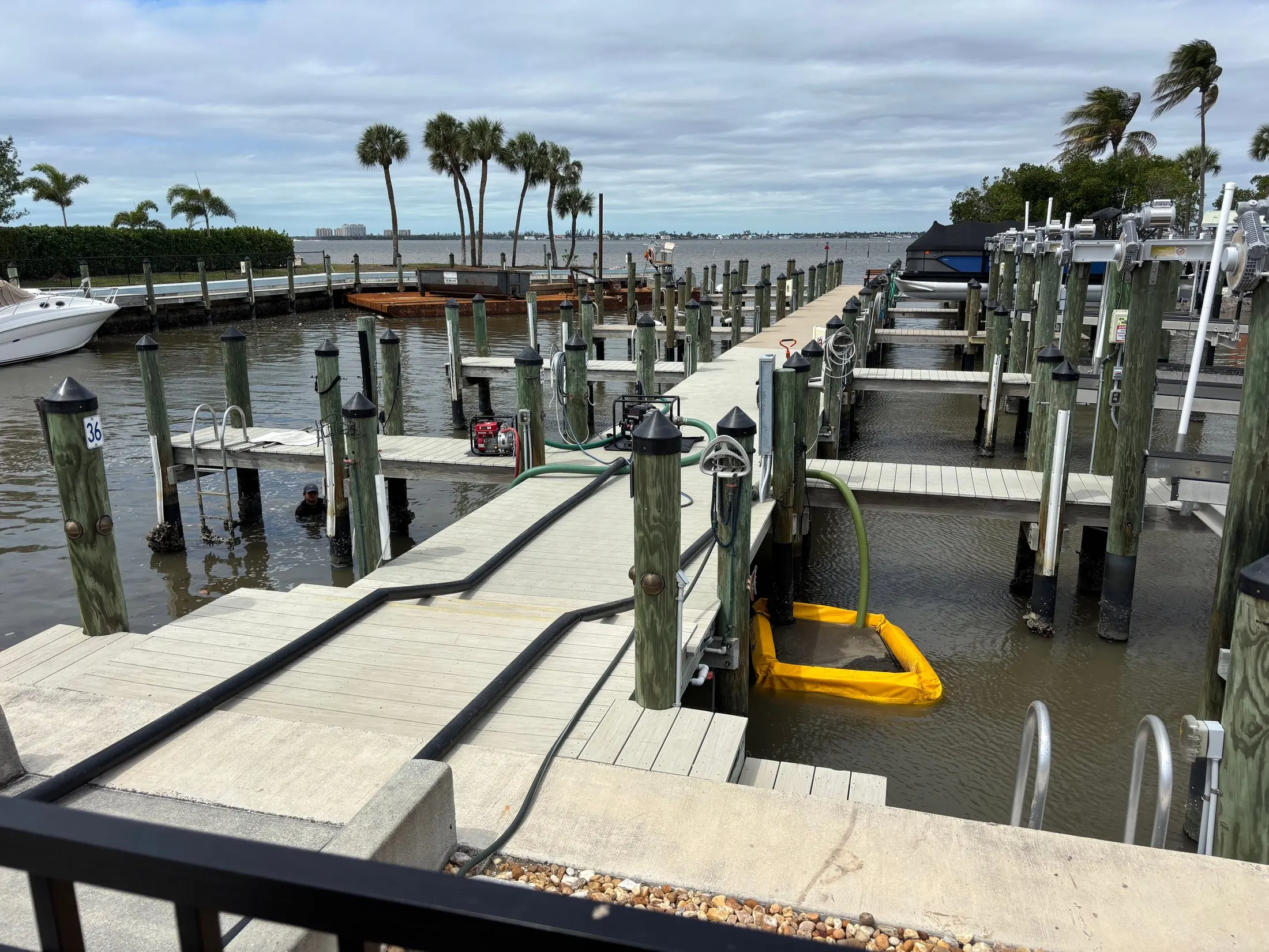 Dock & Dredge: docks and boat-lift structures with hoses beside the water