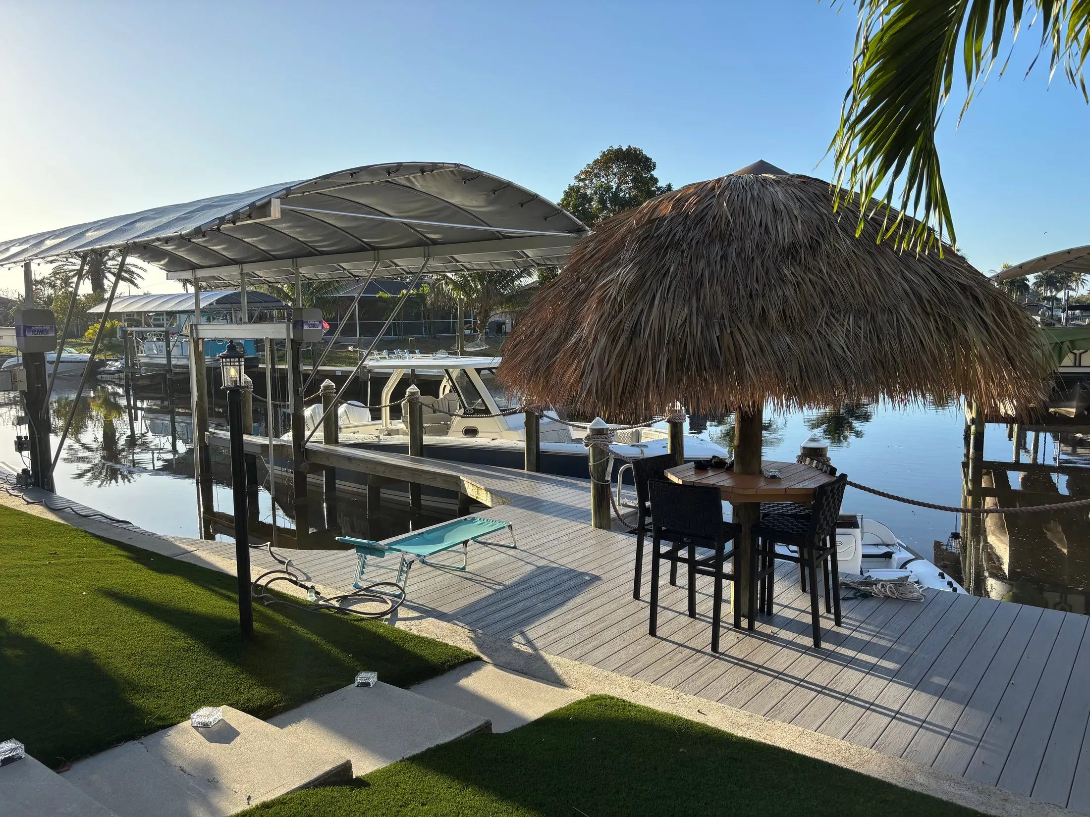 Dock & Dredge: waterfront deck with a covered seating area and boat lift